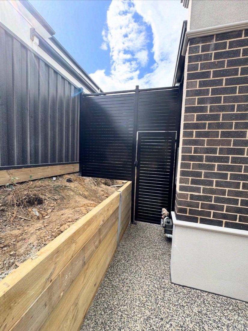 Black aluminium slat gate and exposed aggregate side path
